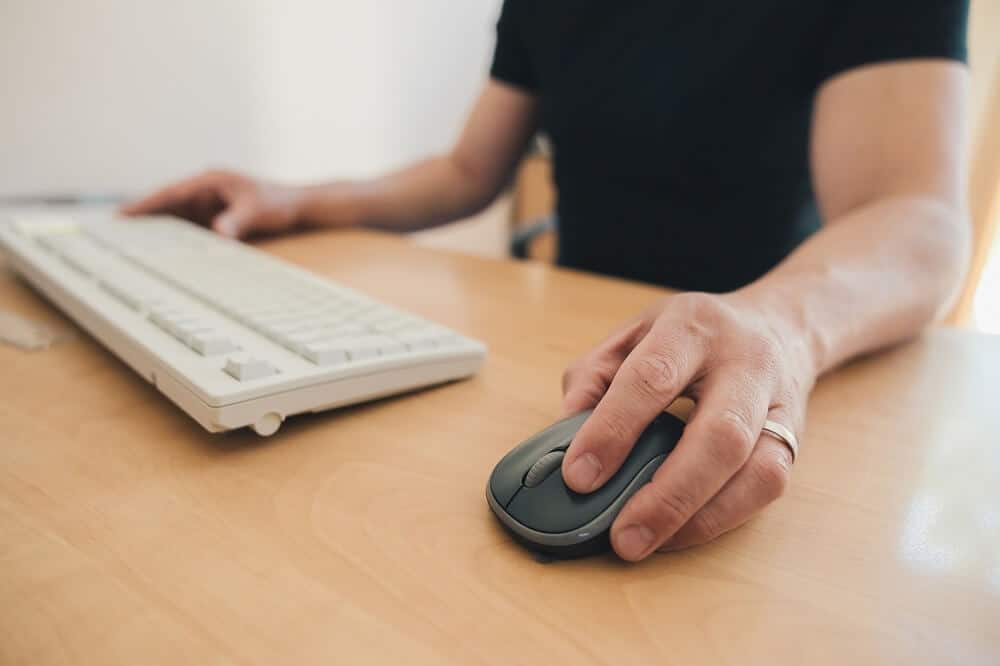 Canhoto usando o mouse do computador com a mão esquerda